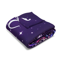 A folded purple blanket with a white crescent moon and star pattern, shown on a clean white background.