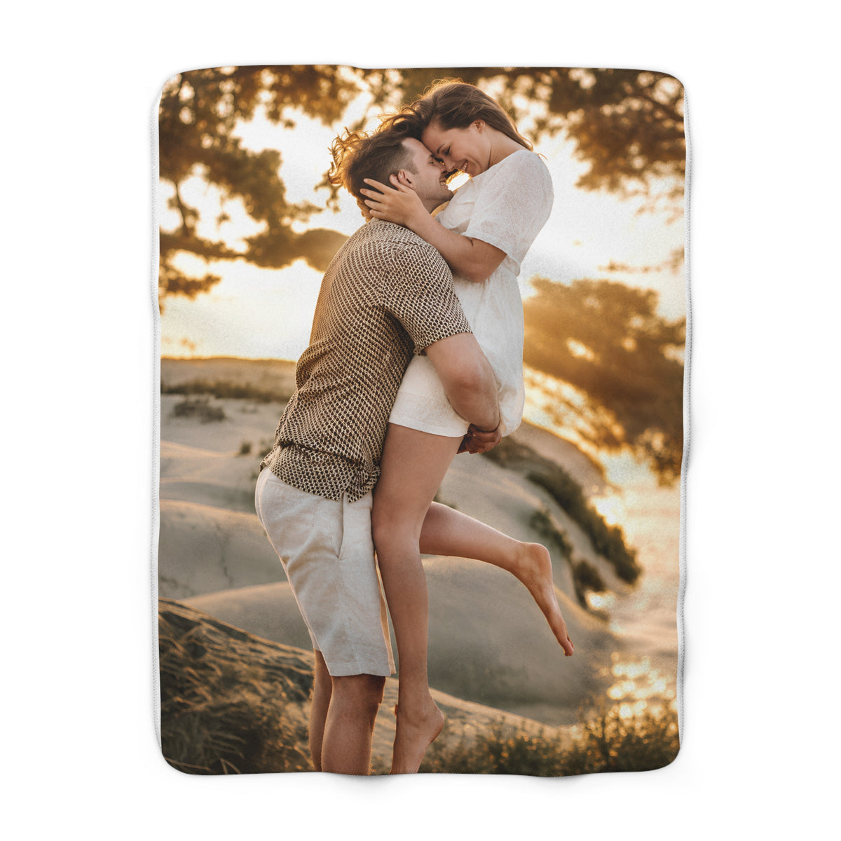 A rectangular photo blanket with a custom printed image of a couple embracing on a beach at sunset, shown against a plain white background.