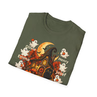 An olive green short-sleeve t-shirt with a Halloween-themed graphic print, shown on a clean white background. The graphic features a haunted house, a witch's hat, ghosts, pumpkins, and the names 'Emma', 'Henry', and 'Josef' printed in white text.
