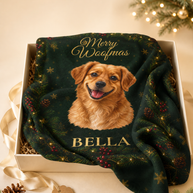 A personalized Christmas blanket featuring a portrait of a golden retriever named 'BELLA' on a dark green holiday background with pinecones and gold lettering, presented in a gift box with festive props.